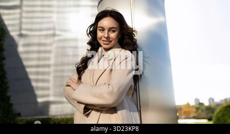 Selbstbewusste Geschäftsfrau, die draußen in die Kamera blickt Stockfoto