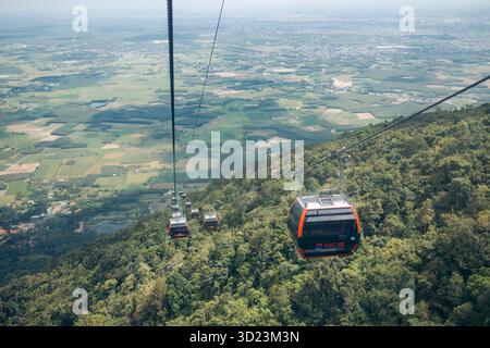 Seilbahnen fahren über üppig grüne Wälder und Felder mit einem weiten Blick auf die Landschaft. Black Virgin Mountain, Tay Ninh, Vietnam Stockfoto