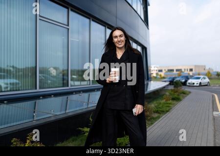 Porträt einer erfolgreichen Reifen Geschäftsfrau mit Kaffee vor dem Hintergrund eines Bürogebäudes Stockfoto