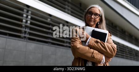 Porträt einer erfolgreichen Geschäftsfrau mit Laptop in der Hand außerhalb des Büros Stockfoto