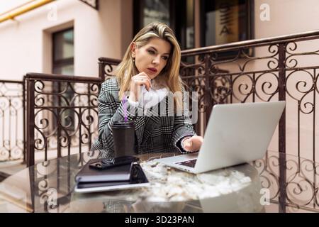 Geschäftsfrau, die außerhalb des Büros an einem Laptop arbeitet Stockfoto