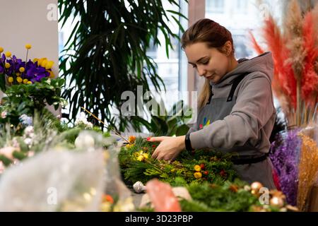 Minsk, Weißrussland - 20. Dezember 2021: Floristin bei der Arbeit in einem Blumenladen Stockfoto