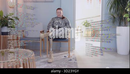 Sitzender Soldat in Uniform mit Smartphone auf Stuhl mit Beinprothese in der Lobby Stockfoto