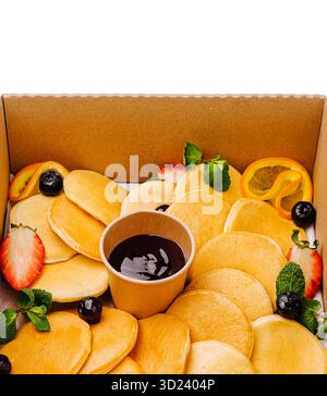 Köstliche Pfannkuchen in einer Box mit frischem Obst und Sirup Stockfoto