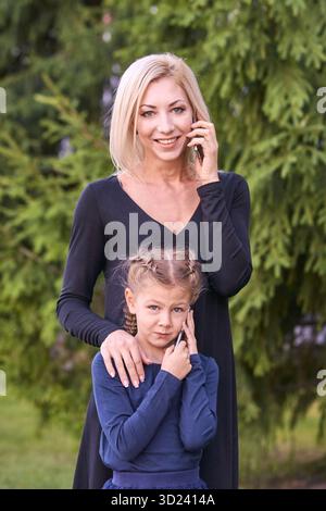 Kaukasische erwachsene Mutter mit Kind in der Natur, lächelnd und redend Stockfoto
