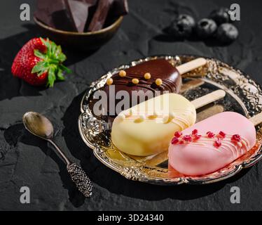 Köstliches Eis auf einem dekorativen Tablett mit frischem Obst und Schokolade Stockfoto