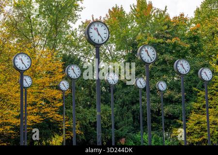 Die Kunstinstallation Zeitfeld im Volksgarten Park in Düsseldorf-Oberbilk, bestehend aus insgesamt 24 auf 6 Meter Höhe montierten Bahnhofsuhren Stockfoto