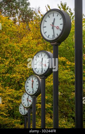 Die Kunstinstallation Zeitfeld im Volksgarten Park in Düsseldorf-Oberbilk, bestehend aus insgesamt 24 auf 6 Meter Höhe montierten Bahnhofsuhren Stockfoto