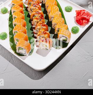 Frisch zubereitete Sushi-Brötchen auf einem weißen Teller garniert mit Wasabi Stockfoto