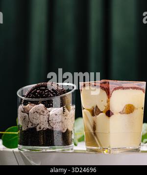 Köstliche Desserts, serviert in klaren Gläsern mit Schichten Sahne und Keksen Stockfoto
