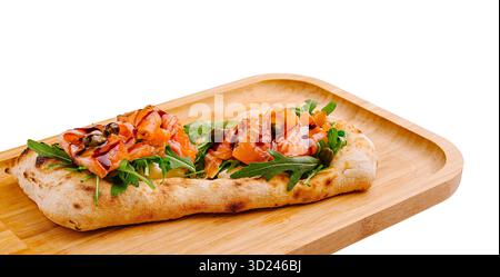 Leckeres Fladenbrot mit Räucherlachs und Gemüse auf einem Holzbrett Stockfoto