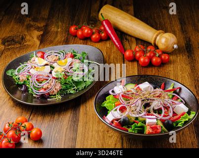 Frische Salate und Gemüse auf einem Holztisch während der Zubereitung der Mahlzeiten Stockfoto