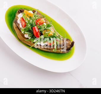 Köstliche geröstete Auberginen mit frischem Gemüse und lebendiger Sauce Stockfoto