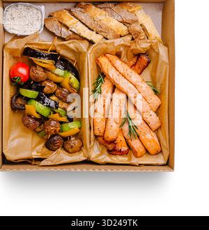 Köstlicher gegrillter Lachs und Gemüse in einer Take-Out-Box Stockfoto