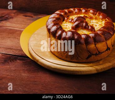 Frisch gebackener Kuchen auf einem Holzbrett in warmen Tönen in gemütlicher Umgebung Stockfoto