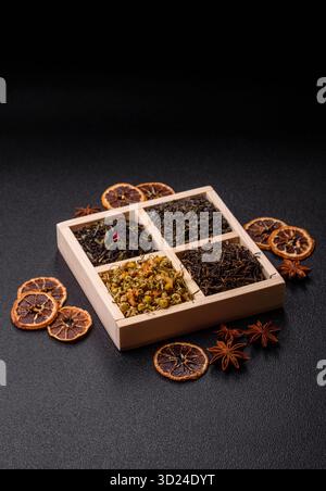 Eine Holzkiste mit verschiedenen Arten von getrocknetem Tee, grünem, schwarzem, Obst und Kamille. Trockener Tee in der Schachtel Stockfoto