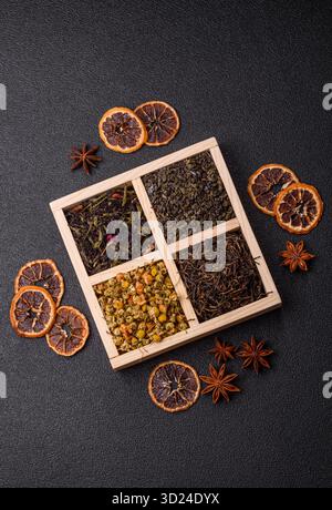 Eine Holzkiste mit verschiedenen Arten von getrocknetem Tee, grünem, schwarzem, Obst und Kamille. Trockener Tee in der Schachtel Stockfoto