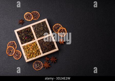 Eine Holzkiste mit verschiedenen Arten von getrocknetem Tee, grünem, schwarzem, Obst und Kamille. Trockener Tee in der Schachtel Stockfoto