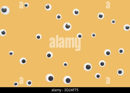 Verstreute Augen auf gelbem Hintergrund mit verspieltem und kreativem Design Stockfoto