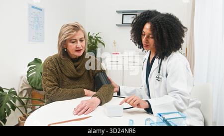 Dr. Überprüft Den Blutdruck Älterer Frauen Während Des Clinic Health Visit Stockfoto