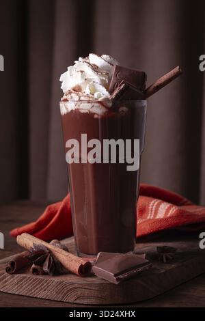 Heißes Schokoladengetränk, garniert mit Schlagsahne, Schokoladenspänen und einem Zimtstab Stockfoto