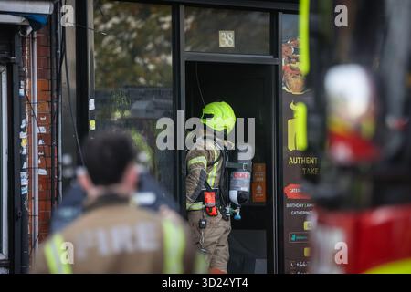 LONDON, Großbritannien - 30. Oktober 2025: Feuerwehrleute der Londoner Feuerwehr gehen in einem Fast-Food-Restaurant an der Sangley Road in Catford, South London, in Brand. Fünf Feuerwehrfahrzeuge und ein Kommandofahrzeug waren am Tatort. London Ambulance Service war ebenfalls anwesend, verließ aber kurz darauf, da keine Verletzungen gemeldet wurden. Die Brandursache ist noch nicht bekannt. Stockfoto