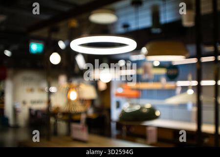 Abstrakte, verschwommene Ansicht des Innenraums eines Einzelhandels. Unscharfer Hintergrund, Weitwinkelansicht, Bokeh-Highlights, keine Personen Stockfoto