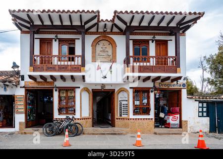 Villa de Leyva, Boyaca, Kolumbien - 19. November 2023: Ein Gebäude im Kolonialstil, in dem das Posada Plaza Hotel und eine Apotheke untergebracht sind, befindet sich in einer Straße in der Villa de Leyva. Stockfoto