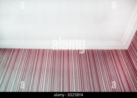 Innenfragment mit weißer Deckenverkleidung und rosa gestreiften Tapeten Nahaufnahme sauberer Hintergrund für Design horizontalen Rahmen niemand Stockfoto