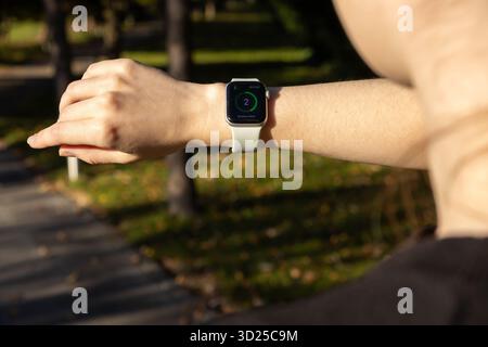 Poznan, Polen – 24. September 2025: Fokus auf den Arm einer Person, die eine Apple Watch trägt, und die Kennzahlen „Outdoor Walk“ genau verfolgen, um eine erfrischende Aktivität zu erhalten Stockfoto