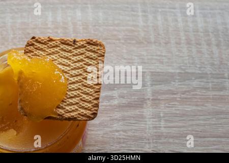 Goldener Honig, der auf knusprigen Keksen unter der warmen Morgensonne fließt Stockfoto