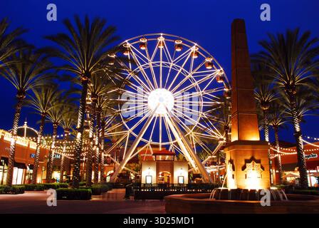 Irvine, CA, USA 25. März 2013 Ein Riesenrad, Palmen und die umliegenden Gebäude werden nachts im Spectrum, einem Einkaufsbummel, beleuchtet Stockfoto