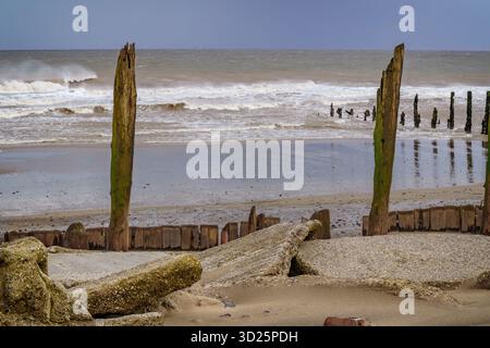 Verfallene Küstenverteidigungen stehen vor rauen Wellen der Nordsee, Sporn Head, Yorkshire, Großbritannien. Stockfoto