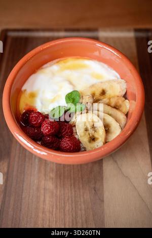 Köstliche Frühstücksschale mit frischem Obst und cremigem Joghurt in gemütlicher Umgebung Stockfoto