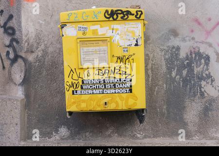 Ein krumm und entrüttelter Briefkasten der Österreichischen Post, der Vandalismus und Vernachlässigung im öffentlichen Raum und den Niedergang der analogen Postdienste symbolisiert. Stockfoto