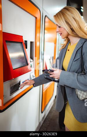 Frau, die am Automaten U-Bahn-Ticket kauft Stockfoto