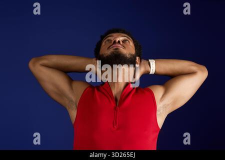 Ein starker sportlicher Mann mit lockigem Haar und Bart führt Trainingsroutinen durch und zeigt Hingabe. Stockfoto