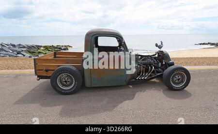 Klassischer Hot Rod Truck parkt an der Strandpromenade Strand und Meer im Hintergrund. Stockfoto