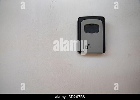 Schlüsselschloss aus Metall an strukturierter weißer Wand montiert Stockfoto