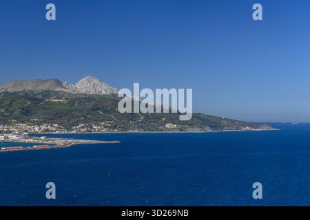 Weite Küstenlandschaft mit Ceuta, Hafeninfrastruktur und bergigem Gelände dahinter. Stockfoto