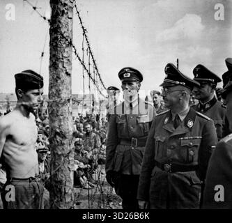 MINSK, RUSSLAND - 15. August 1941 - SS-Handlanger Heinrich Himmler inspiziert ein Kriegsgefangenenlager in Minsk, Russland während der Operation Barbarossa im Zweiten Weltkrieg. Einer der Architekten der „Endlösung“ - hauptsächlich gegen die Juden gerichtet, hatte auch einen Hass auf die Slawen, von denen viele in den Konzentrationslagern landen, an denen er maßgeblich beteiligt war - Foto: Geopix Stockfoto