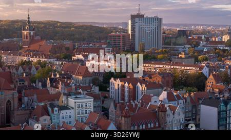 Aus der Vogelperspektive von Danzig, Polen, zeigt pastellfarbene Stadthäuser, die Türme der Heiligen Maria und Katharina, den Fluss Motlawa und den mittelalterlichen Kran, Herbstlicht und Stockfoto