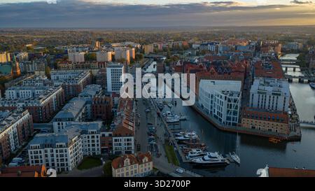 Aus der Vogelperspektive von Danzig am späten Nachmittag sehen Sie den Fluss Motlawa, Yachthäfen, pastellfarbene Stadthäuser, Kornspeicher aus roten Backsteinen auf Granary Island, St. Marys Kirche und Stockfoto