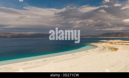 Die Kombination aus dem reinen weißen Flachwasser des Salda-Sees und dem tiefblauen Wasser mit der dramatischen bewölkten Berglandschaft. Einzigartige Natur. Stockfoto