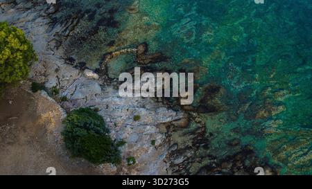 Felsige Küste und das faszinierend klare türkisfarbene Wasser des Meeres. Stockfoto