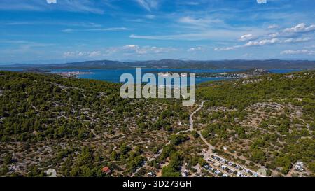 Grüne Hügel und felsiges Gelände der kroatischen Küste, die zu einem atemberaubenden Panorama des ruhigen Meeres führen. Stockfoto