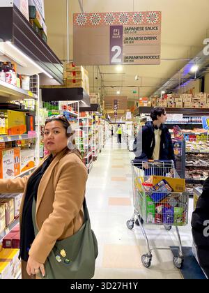Eine Frau wählt Produkte in einem asiatischen Supermarkt in London, Großbritannien Stockfoto