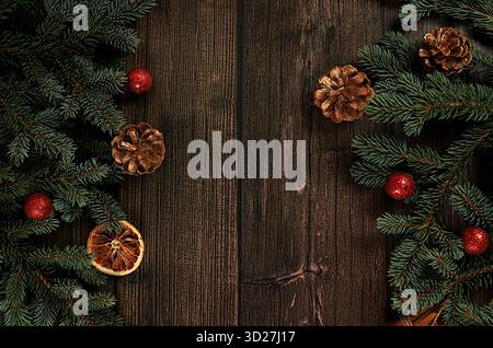 Weihnachten und Neujahr 2025 Komposition, Hintergrund mit blauen Tannenzweigen mit Feiertagsdekorationen auf dunklem Tisch, Banner für Feiertagsschirm, Vorlage Stockfoto