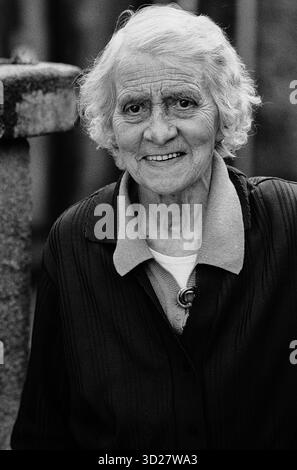 Dieses Schwarzweiß-Bild zeigt eine lächelnde ältere Frau, aufgenommen während der jährlichen Well Dressing-Veranstaltung in Chesterfield, Großbritannien. Das Foto fängt einen ehrlichen Moment ein, in dem ein Teilnehmer das Festival genießt. Die Lage liegt wahrscheinlich im historischen Stadtzentrum, wo die gut Dressing stattfindet. Stockfoto