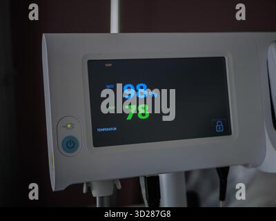 Medizinischer Monitor zeigt Sauerstoffsättigung 98 und Puls 78 Schläge/min im Krankenhausraum an, moderne Technologie im Gesundheitswesen zeigt Vitalparameter auf dem digitalen Bildschirm an. Stockfoto